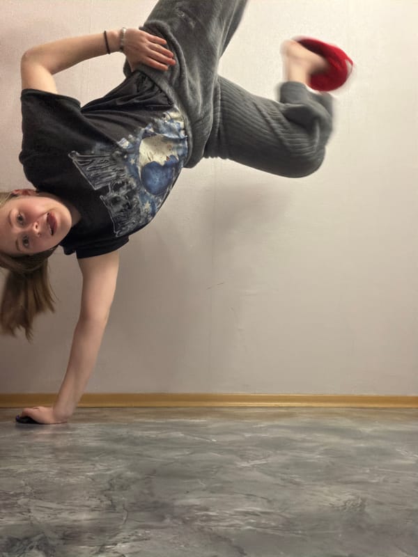 Young person and grey cat photographed during indoor playtime