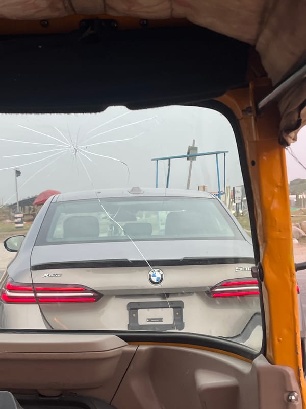 Rickshaw passenger captures cracked-window street view in Karum