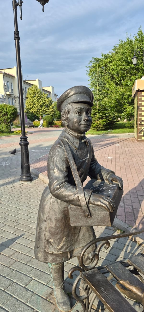 Bronze statues, blooming lilies, and a sidewalk cat in Ussuriysk