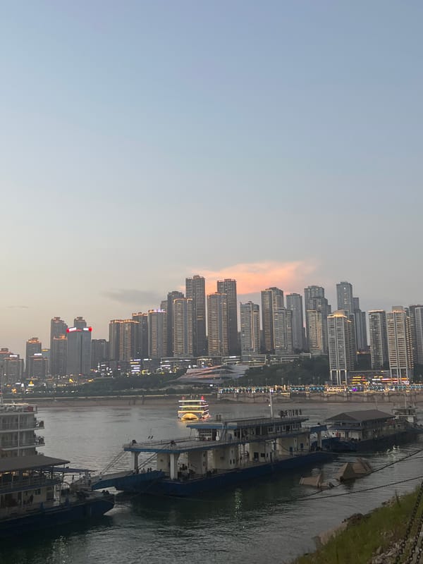 Chongqing's Yangtze riverfront at dusk, bridges and skyline lit up