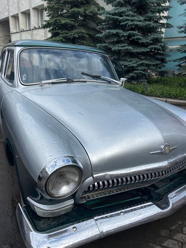 Vintage car on wet cobblestones amid ornate historic city streets