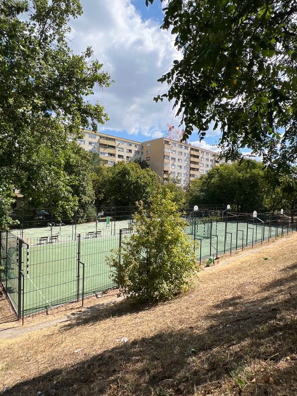 Budapest street-level mix: sports court meets modern office block