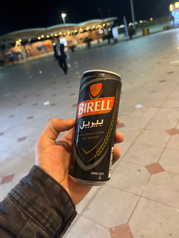 Person enjoys non-alcoholic beverage outdoors in Egyptian city at night