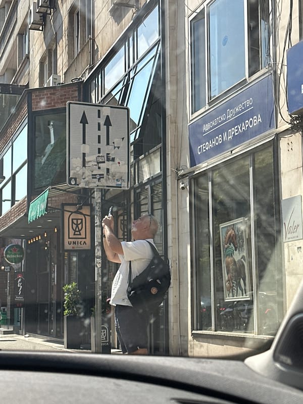 Phone and mug on a Sofia sidewalk, July morning