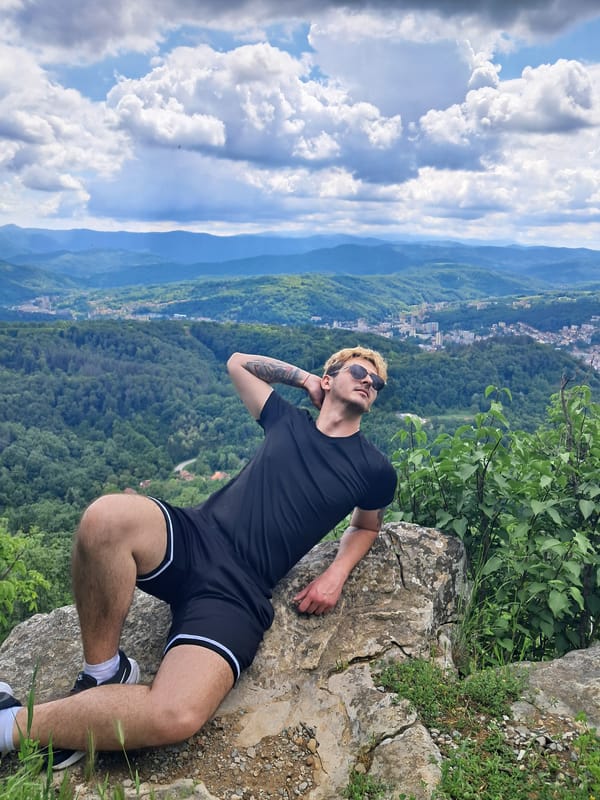 Three men sightsee from rocky outcrop overlooking Gabrovo valley