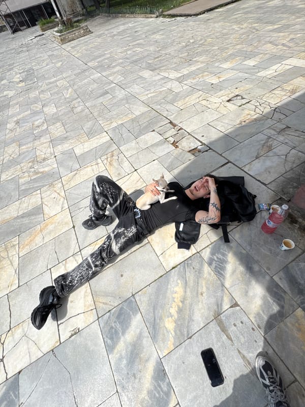Man lies on pavement holding dog in Karlovo, Bulgaria