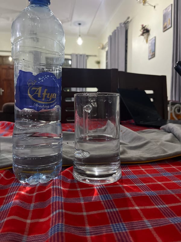 Water bottle and glass observed on plaid surface in Dar es Salaam