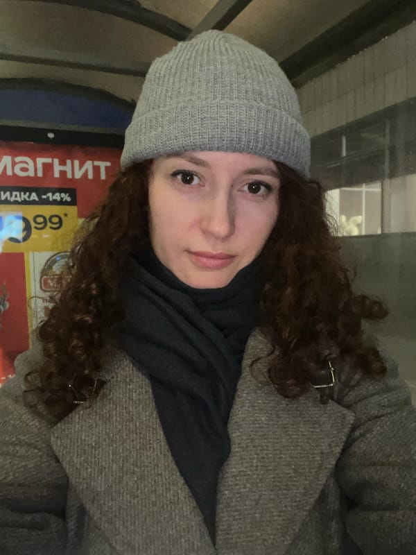 Woman takes selfie near store in rainy Saint Petersburg