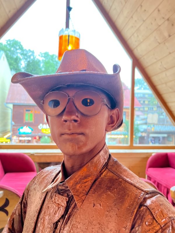 Copper-painted living statue inside Zakopane, cowboy hat and glasses