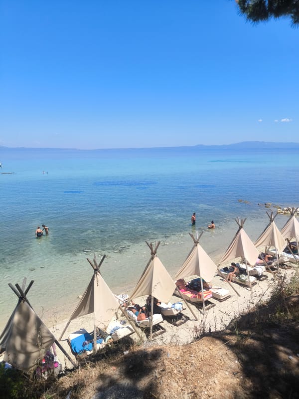 Quiet beach setup with conical tents on Kassandra's shore