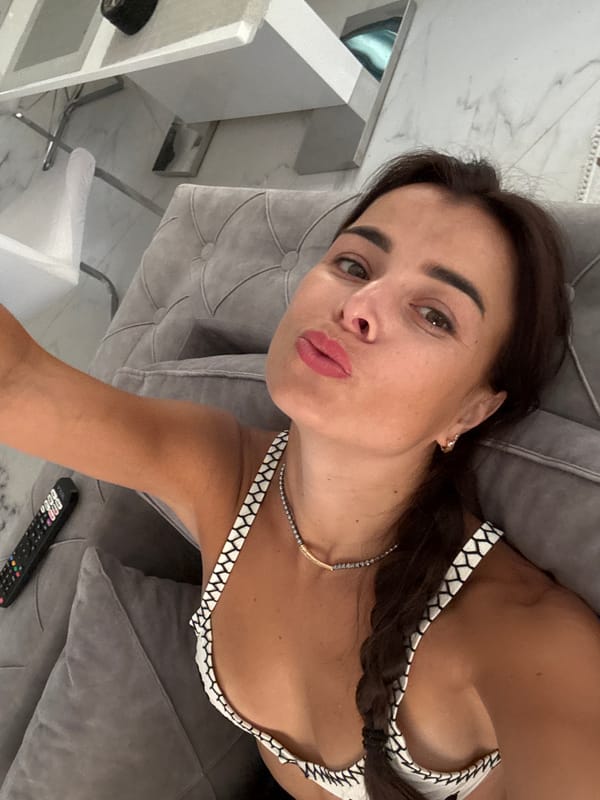 Couch selfie session in a black-and-white bikini top