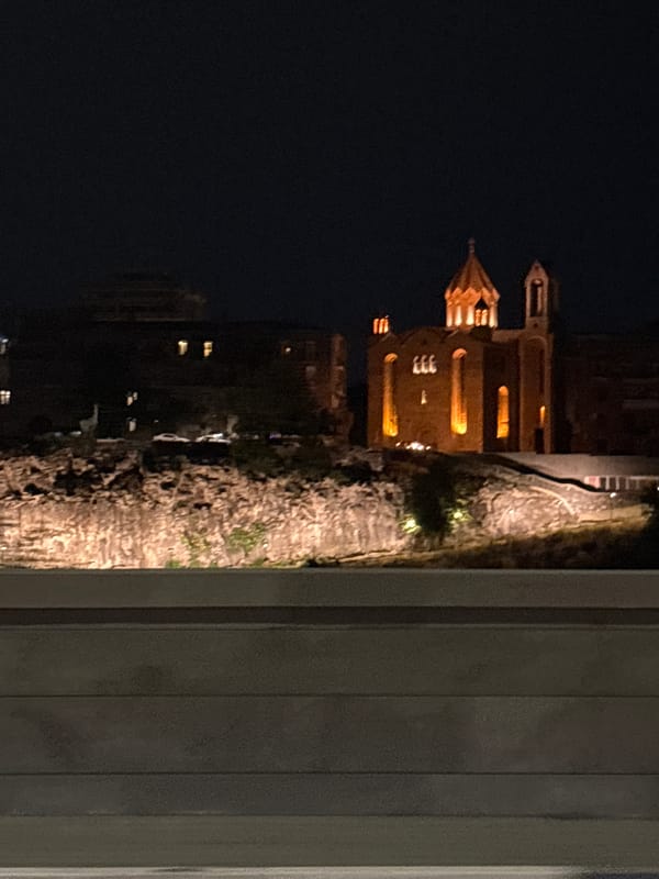 Nighttime drive through Yerevan, passing a lit cathedral