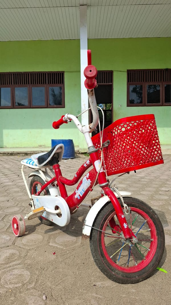 Red kids' bike and a quiet morning sit-down in Grong-grong
