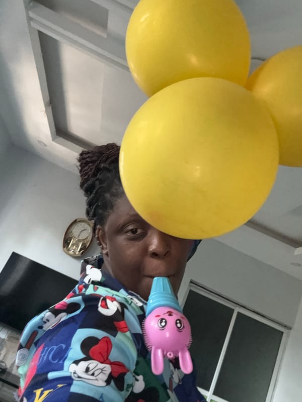 Child plays with bunny toy and balloons in Nigeria
