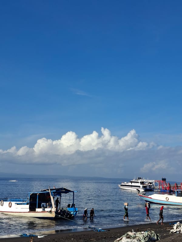 Boats, pier activity, and open water at Dawan's coast