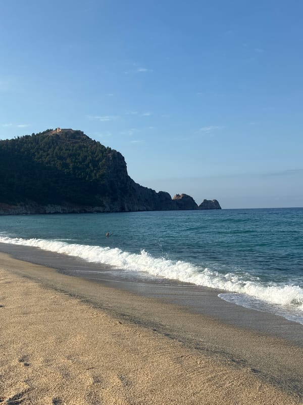 Alanya beach scene with boats and castle backdrop