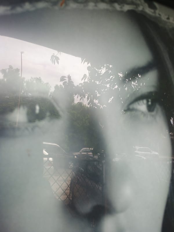 Close-up black-white portrait photograph captured with outdoor reflection overlay