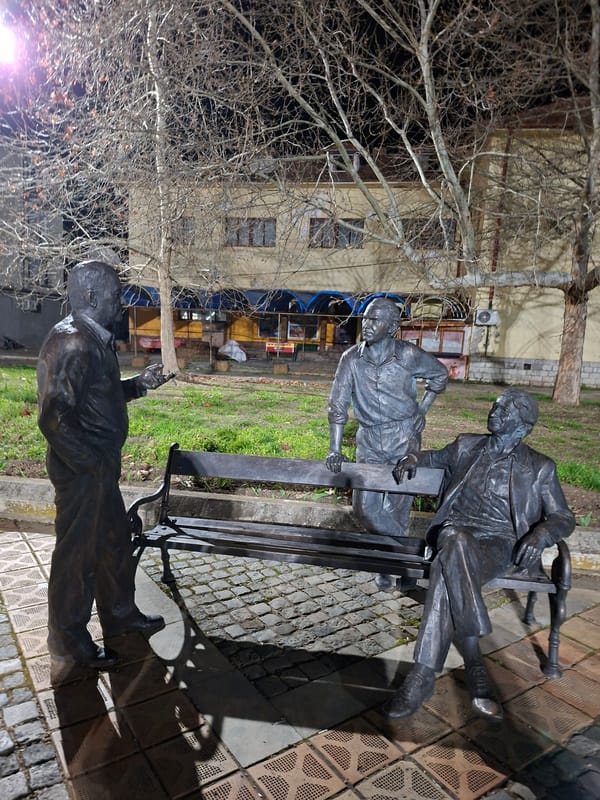 Visitors pose with bronze statues in Levski park
