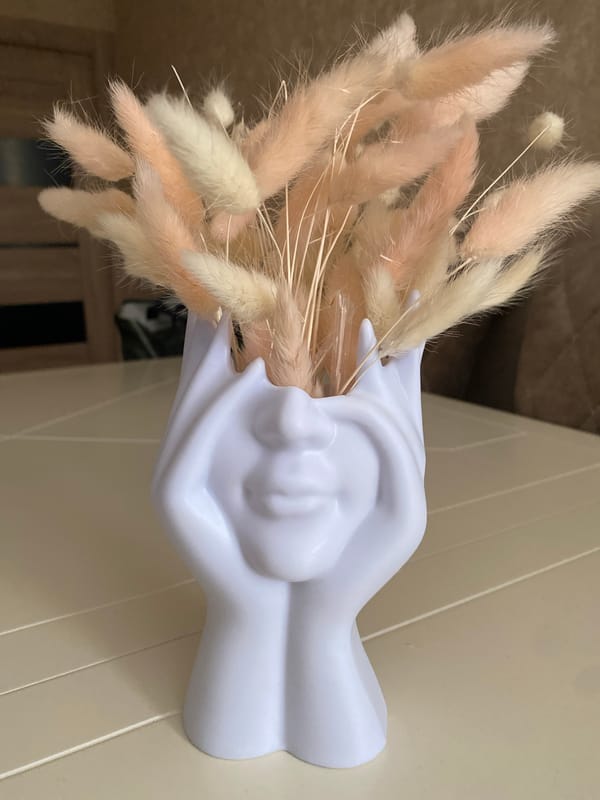 Hand-shaped vase with dried flowers observed on wall