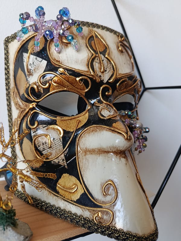 Close-up details: a Venetian mask, bicycle wheel, and stop sign.
