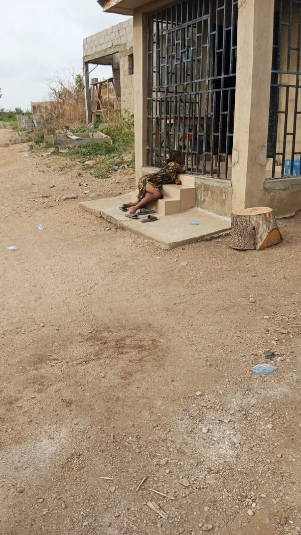 Woman rests on building steps in Zango-ndaji, Nigeria