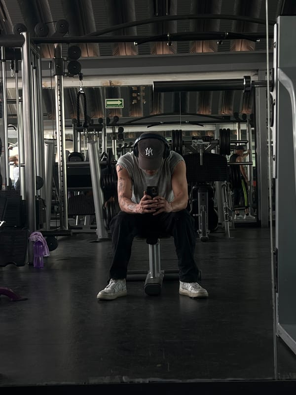Man poses at Mexico City gym; bulldog rests nearby