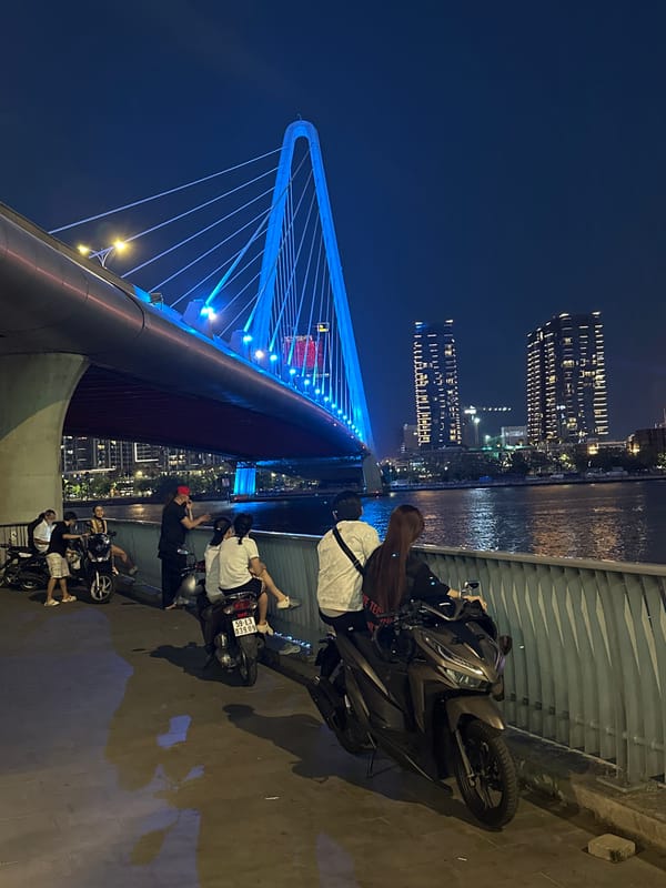 Nighttime pedestrian activity captured on illuminated Thủ Đức bridge