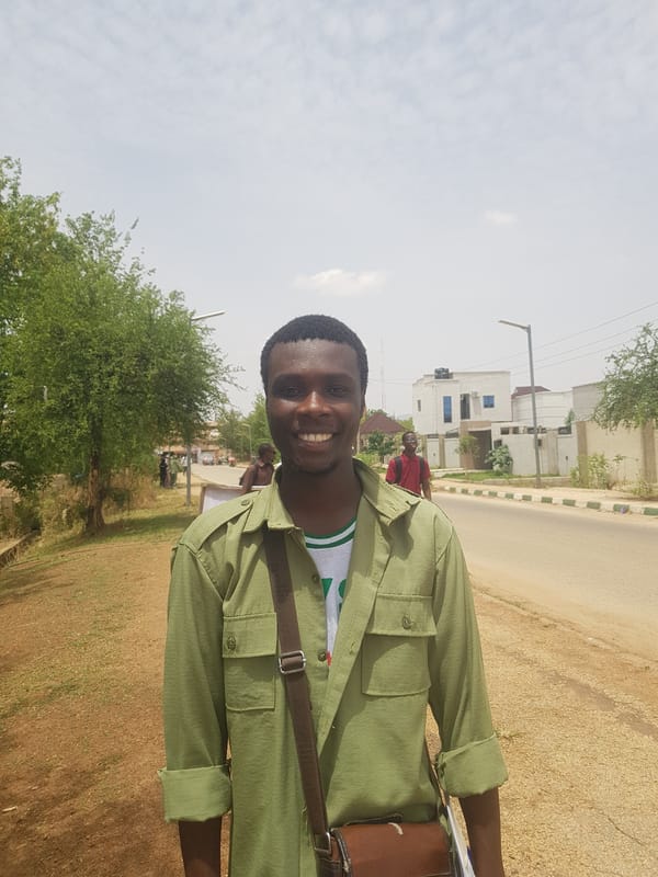 Crowd gathers in Bauchi as motorcycle navigates between cars