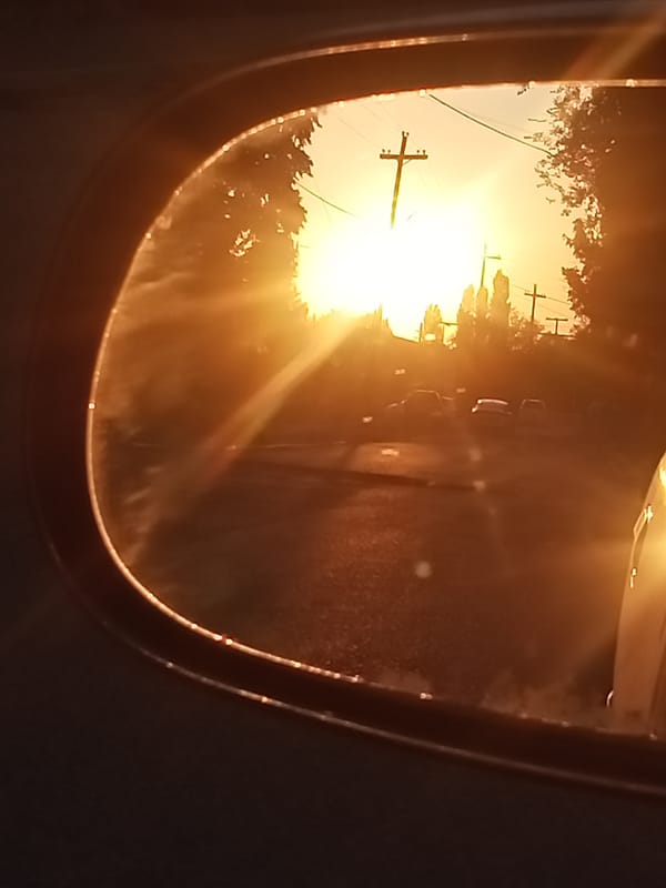 Sunset glare and golden light off a parked car in Sokuluk