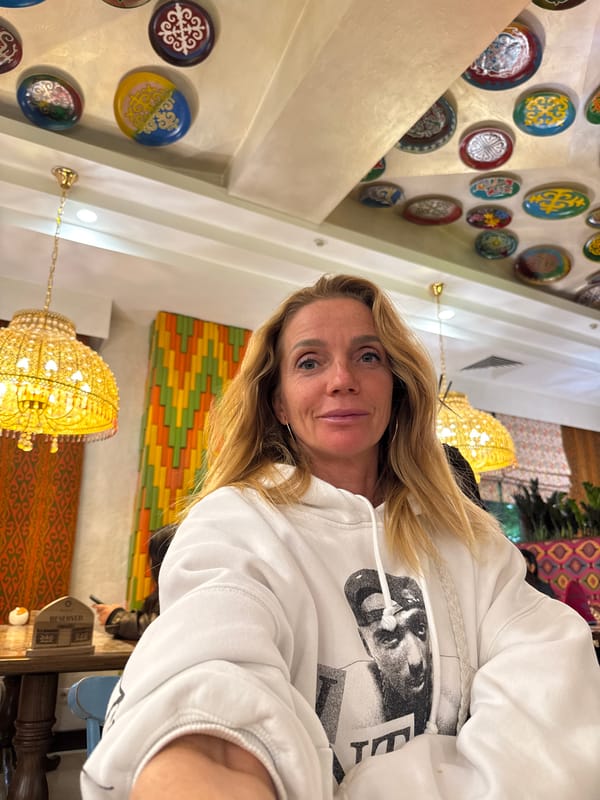 Woman takes selfies in white hoodie in Bishkek