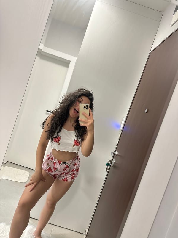 Young woman takes mirror selfies in fruit-themed outfit