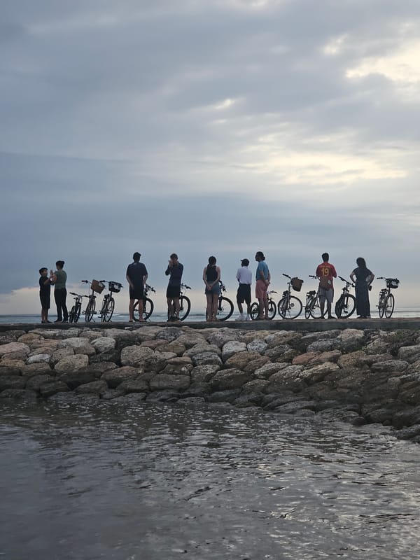 Cyclists gather at Denpasar breakwater for evening ocean viewing