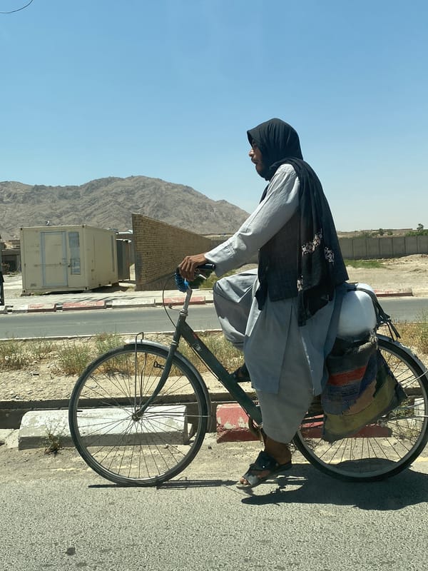 Morning cyclist passes construction yard in Shurandam, Afghanistan