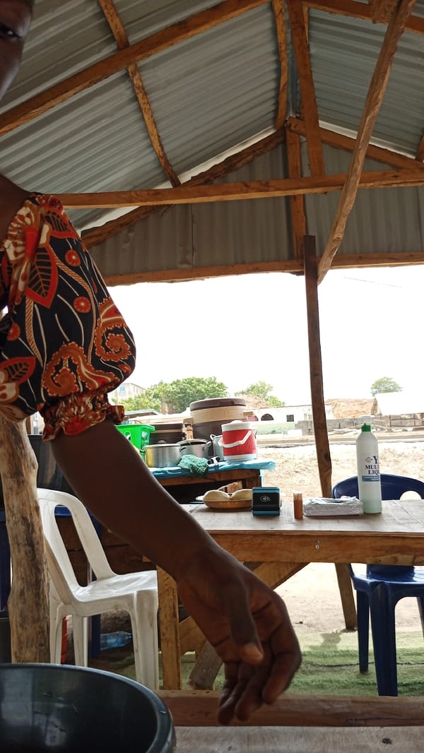 Woman serves food at outdoor stall in Lokoja Nigeria