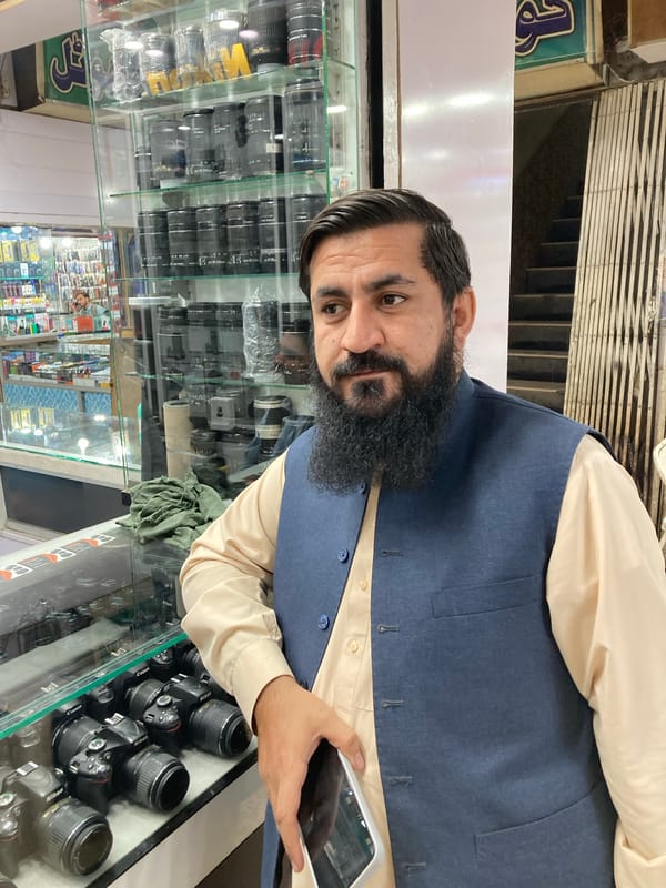 Man browsing camera equipment at electronics store in Quetta