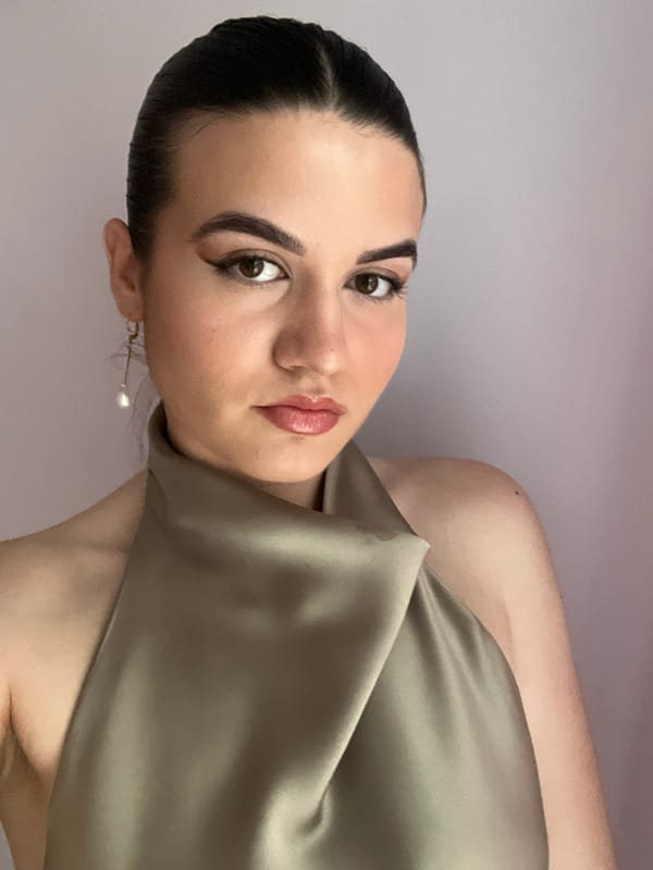 Woman photographed in green dress against purple backdrop