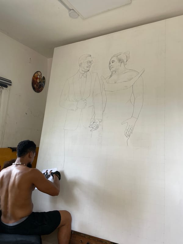 Man examines photograph beside canvas in Ado, Nigeria