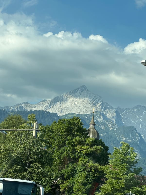 Snow-dusted Zugspitze peaks rise above Garmisch-Partenkirchen forests