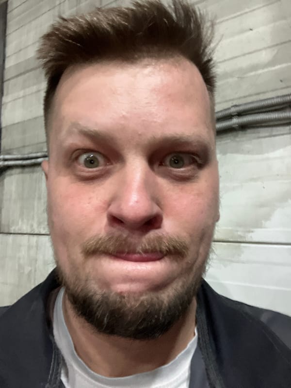 Man takes selfie against industrial wall in Noviy, Russia