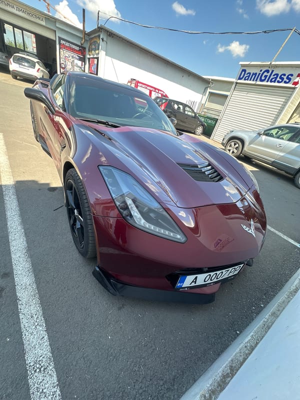 Burgundy Corvette with plate A 0007 PP parked outdoors