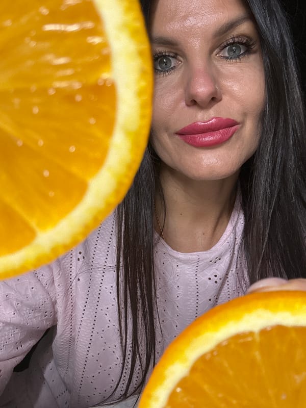 Woman poses with oranges during indoor photo session in Russia