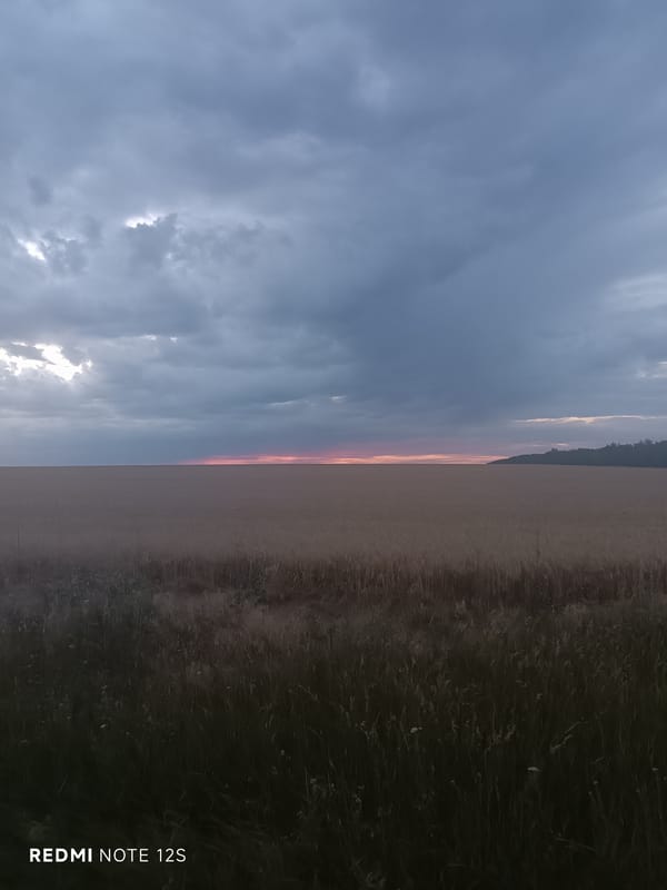 Sunset breaks through storm clouds over Moldova's dry summer fields