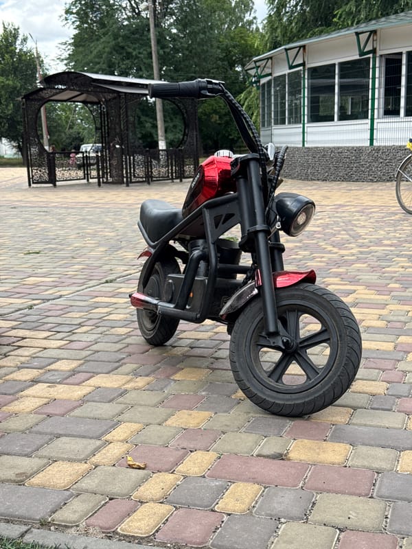 Morning park outing: kids, coffee, and a parked electric scooter