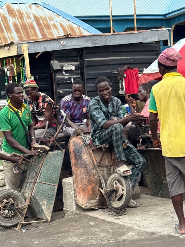Men gather in sunlit market area in Lekki