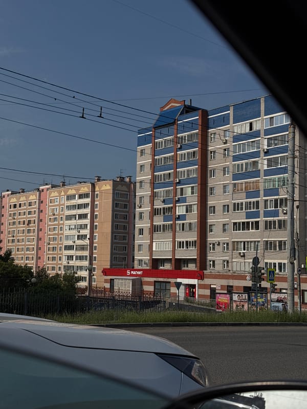 Sunny afternoon traffic and architecture along an Izhevsk main road