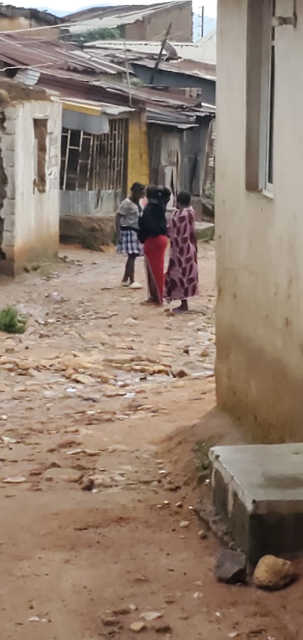 Daily life in informal urban settlement with muddy streets