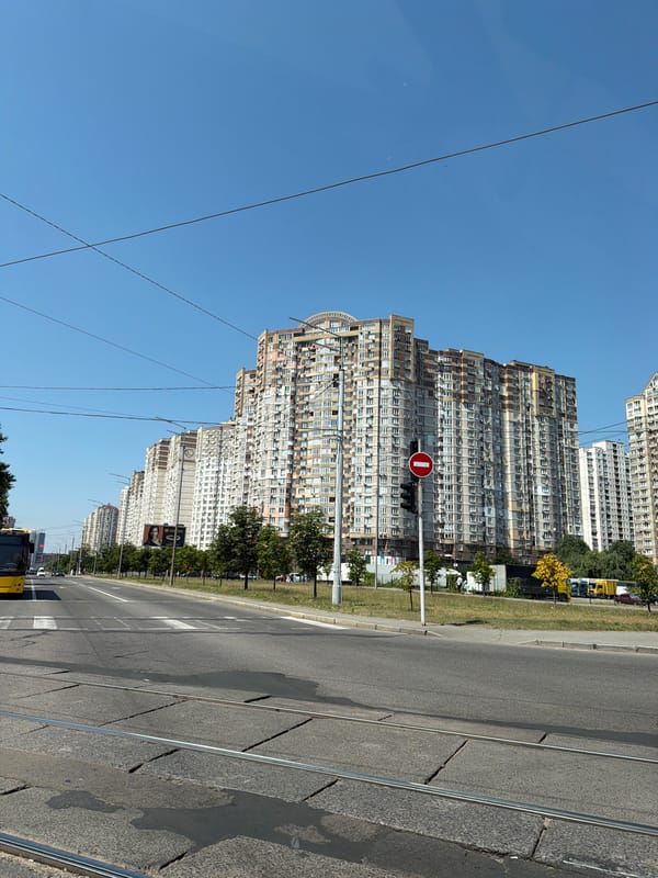 Kyiv street traffic on a sunny morning, trams and apartments