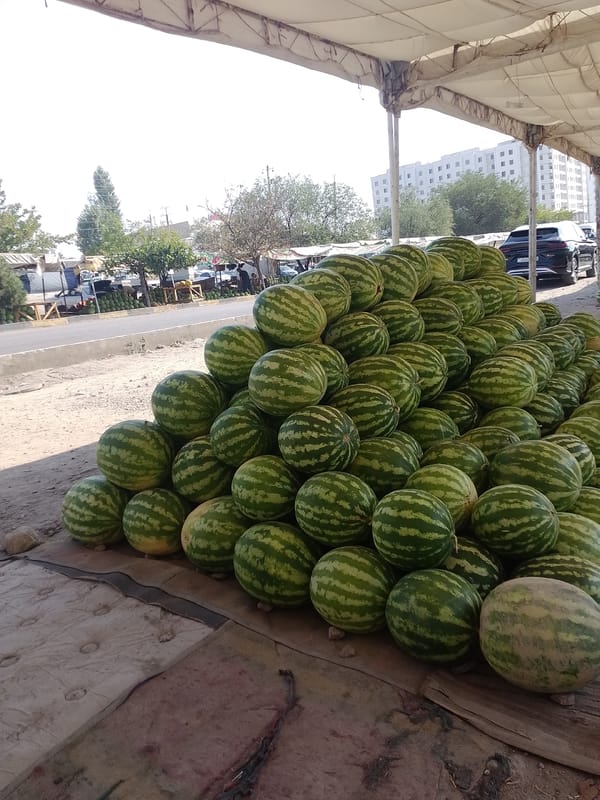 Watermelons piled at an open-air market stall