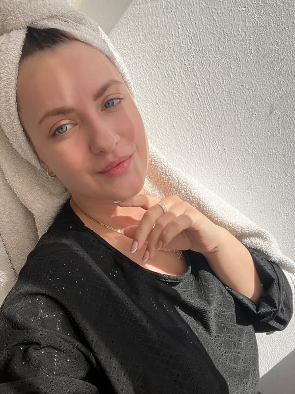 Woman rests with towel-wrapped hair in sunlit Russian interior