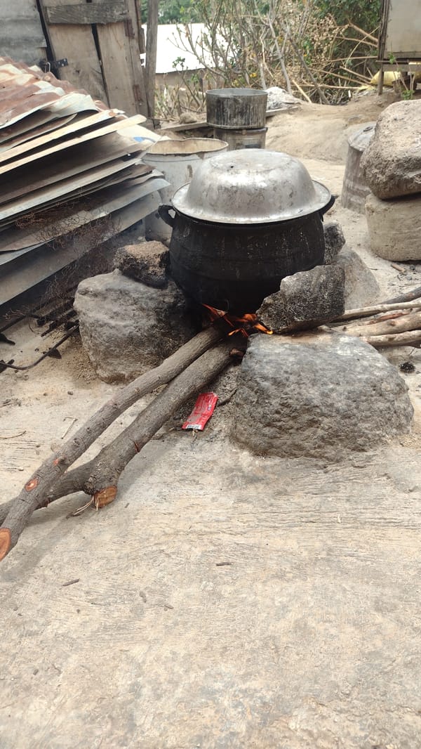 Man conducts outdoor cooking with wheelbarrow in Jos, Nigeria